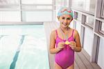 Cute little girl showing her swimming medal at the leisure center