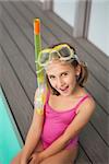 Cute little girl sitting poolside at the leisure center