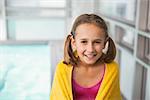 Cute little girl sitting poolside at the leisure center