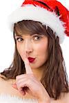 Festive brunette keeping a secret on white background