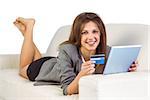 Woman doing online shopping with tablet and credit card at home in the living room