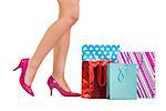 Womans legs in high heels with shopping bags on white background