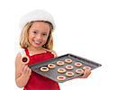 Festive little girl holding fresh cookies on white background