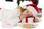 Festive little girl napping on a gift on white background