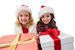 Festive little girls smiling at camera holding gifts on white background