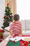 Cute boy drawing festive pictures at home in the living room