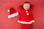 Little boy in santa costume on red background