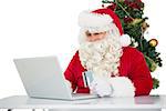 Father christmas shopping online with laptop on white background