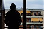 Man looking at city buildings through window.