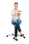 Beautiful female student sitting on a chair with a tablet, isolated over a white background