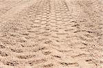 Closeup abstract detail of 4x4 off road tyre tracks going trough a sandy remote desert