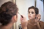 Young woman applying mascara