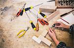 Hands of young craftswoman holding component in pipe organ workshop