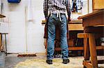 Cropped view of mature craftsman at workbench in pipe organ workshop