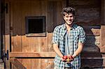 Portrait of young male farmer holding apples, Premosello, Verbania, Piemonte, Italy