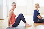 Portrait of mature woman sitting on floor in pilates class