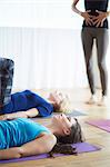 Female teacher with hands on stomach in pilates class