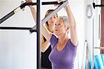 Female student and tutor practicing pilates on trapeze table in pilates gym