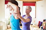 Young female student and tutor in pilates gym