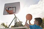 Young man aiming to throw basketball into basketball hoop
