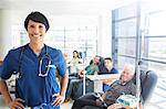 Portrait of doctor with patients receiving medical treatment in background