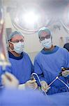 Two male surgeons wearing performing laparoscopic surgery in operating theater