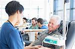 Senior patient undergoing medical treatment talking to doctor in outpatient clinic