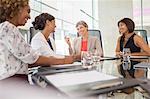 Businesswomen sitting at conference table talking