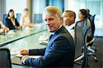 Portrait of  businessman sitting at conference table in conference room