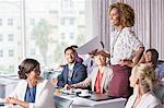 Businesswoman standing with document in hand during presentation in conference room