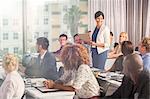 Group of people sitting at desks and listening to speaker