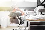 Businessman talking on cell phone at office desk