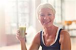 Smiling older woman drinking juice