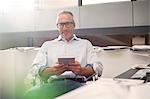 Businessman using digital tablet at office desk