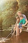 Father and sons fishing in lake