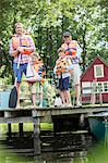 Brothers, father and grandfather wearing life jackets at lake