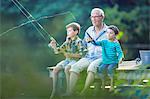 Grandfather and grandsons fishing in lake