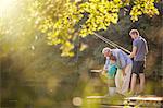 Boy, father and grandfather fishing in lake