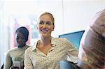 Smiling university student listening to seminar, young woman texting in background