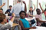 University students raising hands to answer professor