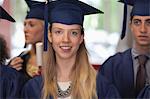 Female student in graduation clothes smiling at camera