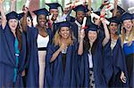 Group of students in graduation clothes posing together for group portrait