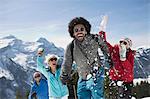 Friends enjoying snowball fight at mountain