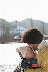 Man kissing woman's forehead in snow