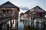 Indonesia, Flores Island, Wuring. The attractive wooden houses at Wuring Fishing Village are built on stilts above the sea and approached on stout bamboo walkways.