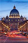 View of the Basilica of St. Peter's and St. Peters Squaredown the Via Della Conciliazione, with traffic  at twilight, Borgo, Rome, Lazio, Italy.