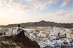 Oman, Muscat. Tourist looking at Mutrah old town, elevated view, at sunrise (MR)