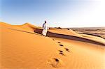 Oman, Wahiba Sands. Bedouin on the sand dunes at sunset (MR)