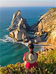 Portugal, Estramadura, Ursa woman sitting on cliff edge (MR)