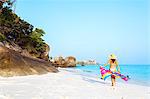 Thailand, Similan islands. Woman in bikini with sarong walking on tropical beach at sunrise (MR)